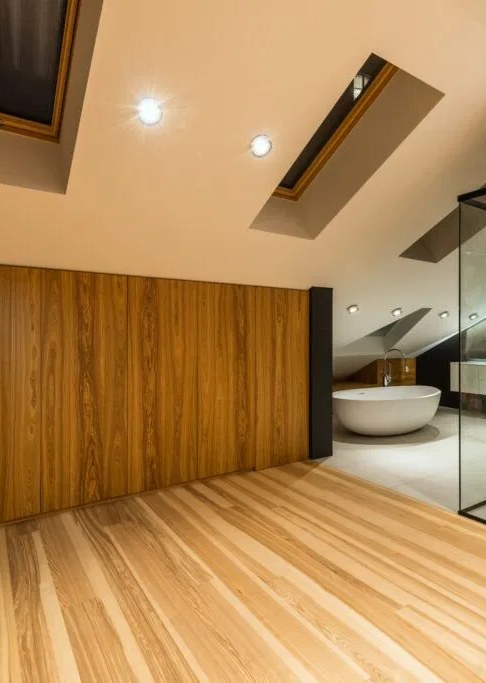 Combles aménagés avec habillage bois et parquet clair